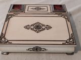 une boîte argentée et blanche posée sur une nappe blanche