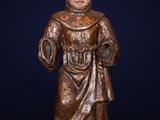 an antique bronze statue of a monk with a green base