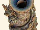 a blue vase with a bird on it sitting on a table