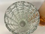 a small glass bowl sitting next to a bottle of liquid