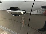a man standing next to a car door with a sticker on it