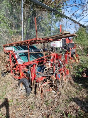 un tracteur rouge assis dans l'herbe