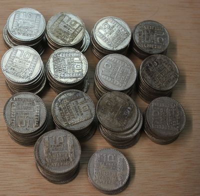 a pile of silver coins sitting on a wooden table