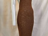 robe en tricot marron posée sur un socle de mannequin, posée sur un socle de mannequin
