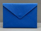 une enveloppe en cuir bleu munie d'un petit rabat sur le dessus
