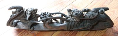 une sculpture représentant un bateau posée sur un plancher en bois