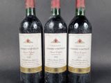 three bottles of red wine sitting next to each other on a table
