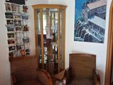 two wicker chairs in a room with a picture on the wall