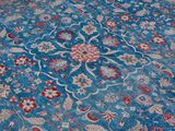 a blue rug with a red and white flower design on it
