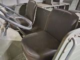 two seats in the back of a truck with a steering wheel