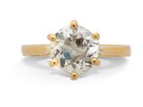 un gros plan sur une bague de fiançailles en or sertie d'un diamant blanc