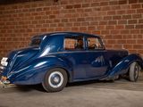 a blue car that is parked in front of a brick wall