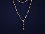 a rosary with a cross and a gold chain on a dark background