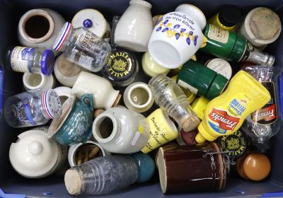 une poubelle bleue remplie de tasses à café et de soucoupes vides