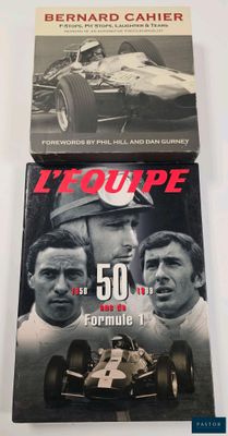 two books on a white table with a black and white photo of a race car