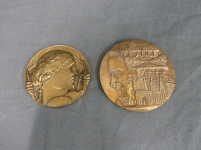 two gold medallions depicting a woman and a castle