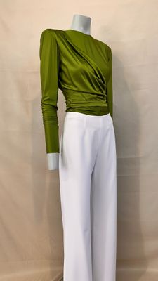 a close up of a mannequin wearing a green top and white pants