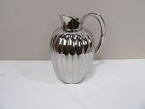 a silver pitcher that is sitting on a table