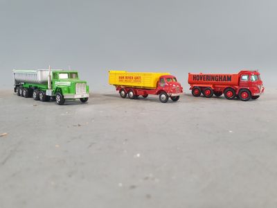 three toy trucks sitting side by side on a table