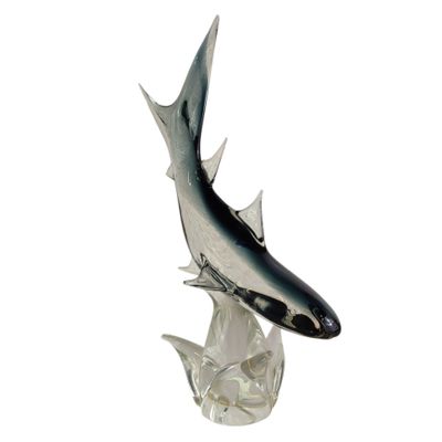 statue représentant un poisson, posée sur un socle transparent, sur fond blanc