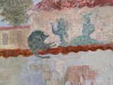 a painting on the wall of a building that has a painting of a man and a cat on it