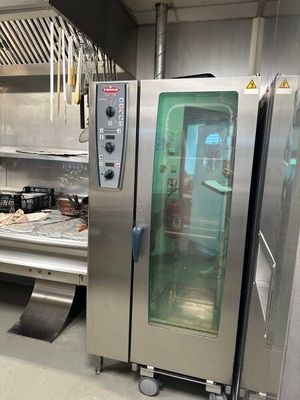 des fours en acier inoxydable dans une cuisine professionnelle disposant d'un grand plan de travail