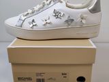 une paire de baskets blanches ornées d'étoiles argentées