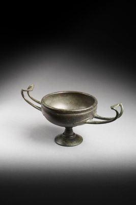 an image of a bronze bowl on a pedestal on a white background
