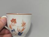 a person holding a cup with a floral design on it