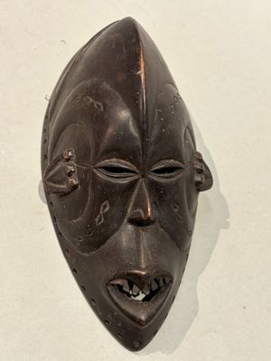 un masque en bois accroché au mur