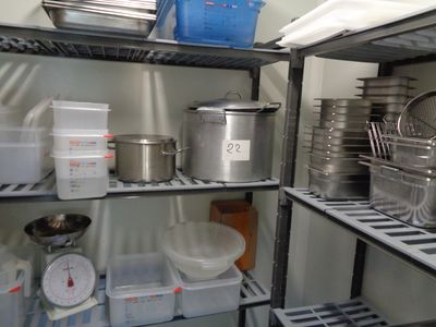de nombreuses casseroles et poêles sur les étagères de la cuisine