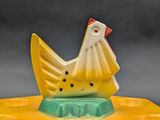a yellow and white chicken on top of a yellow plate