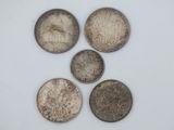 four different types of coins are shown on a white surface
