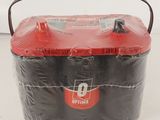 a red and black container with a handle on a table