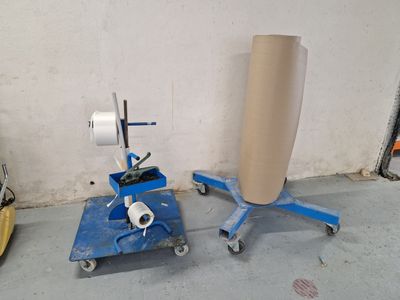 un chariot bleu sur lequel se trouve un rouleau de papier, à côté d'un autre chariot bleu sur lequel se trouve un rouleau de papier