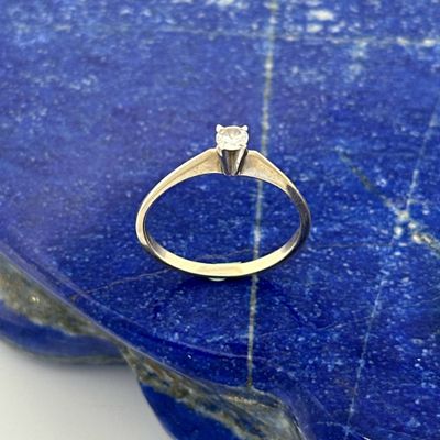 a close up of a diamond ring on a blue stone