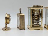 three clocks sitting next to each other on a white surface