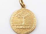 a close up of a gold coin with a tree on it