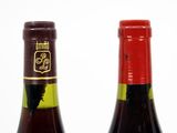 two bottles of wine sitting next to each other on a table