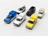 five toy cars that are lined up on a white surface
