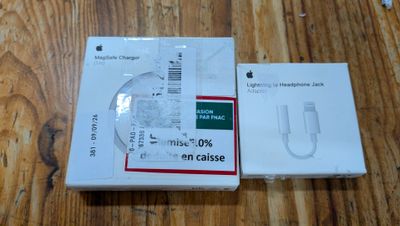des cartons de produits Apple posés sur une table en bois, sur un parquet