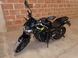 une photo d'une moto garée devant un mur de briques