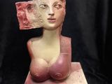 a close up of a sculpture of a woman with a pink hat