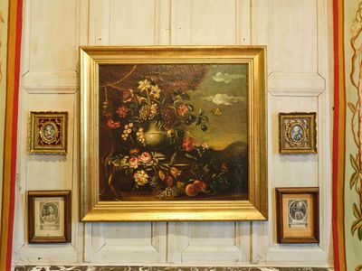 un tableau accroché au mur d'une pièce où sont accrochées des photos
