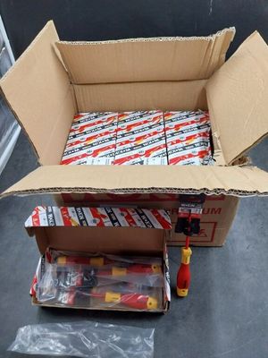 une boîte en carton remplie de piles de différents types, posée par terre