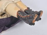 a doll that is sitting in a suitcase on the floor