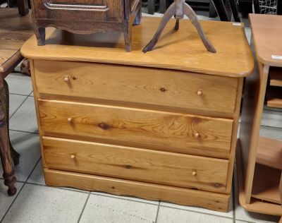 une commode en bois surmontée d'une horloge