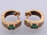an image of a pair of gold earrings with emerald stones