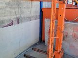a man that is standing next to a forklift