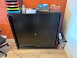 a desk with a chair and a cabinet in the corner